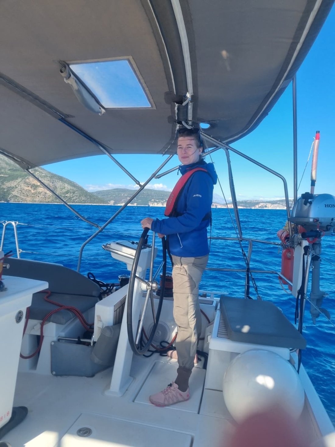 Alice Carpenter at the helm of a sailing yacht